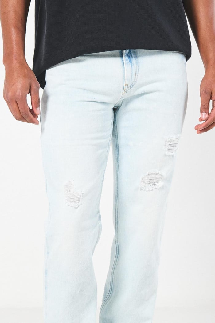 Jean azul claro slim con desgastes, rotos y tiro bajo